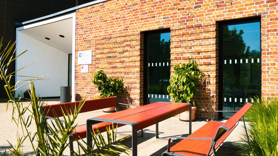 Bänke und und ein Tisch als Außensitzplatz vor dem INBW