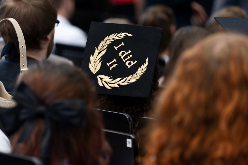 A black hat with the words "I did it" in gold lettering framed by a laurel wreath.