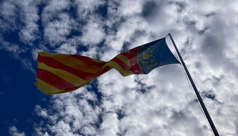Vor einem wolkigen Himmel weht die rot-gold-blaue Flagge der Region Valencia. (öffnet Vergrößerung des Bildes)