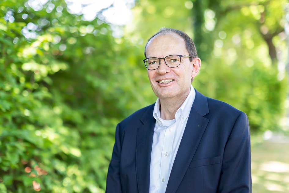 Prof. Dr. Ralf Imhof, im Hintergrund unscharfe grüne Pflanzen