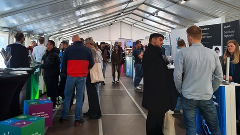 Zahlreiche Messebesucher*innen im Messezelt. 