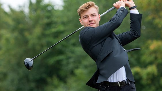 Golfer im Anzug beim Abschlag 