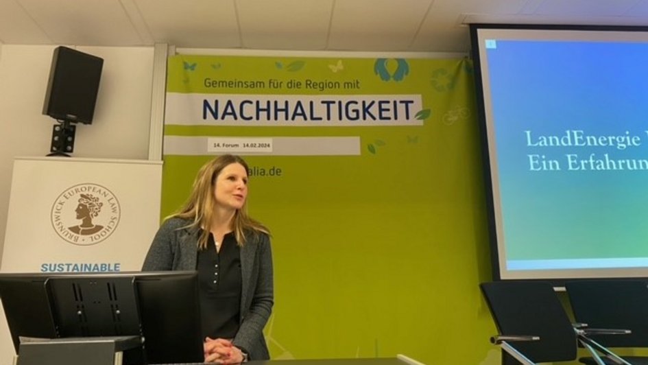 Stefanie Mertz bei ihrem Vortrag. Sie steht am Rednerpult und berichtet von der Gründung der "LandEnergie Bürger eG"