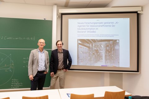 Zwei Professoren der Fakultät Versorgungstechnik im Vorlesungsraum. Im Hintergrund befindet sich der Artikel des Forschungsprojekt, welches an die Leinwand projiziert ist. (öffnet Vergrößerung des Bildes)