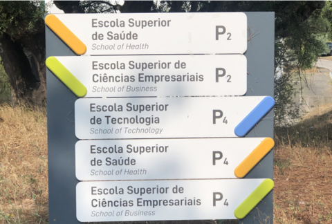 A signpost depicts various destinations at the Escola Superior de Saúde