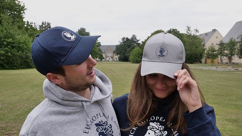 Die Cap trägt das Logo der BELS, die Aequitas, über über dem Schirm. Darum findet sich der kreisförmig angeordnete Schriftzug "Brunswick European Law School" Bei der blauen Cap sind das Logo und der Schriftzug weiß. Bei der Cap in grau melange sind das Logo und der Schriftzug blau. (öffnet Vergrößerung des Bildes)