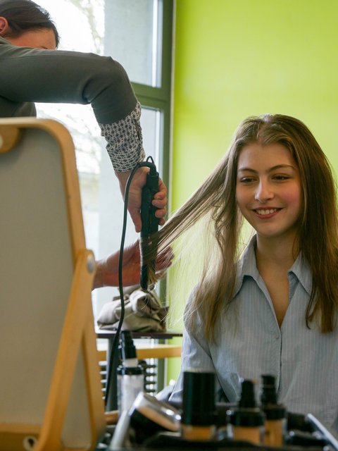 Linda Jedermann stylt eine Messebesucherin für das Bewerbungsfoto-Shooting.