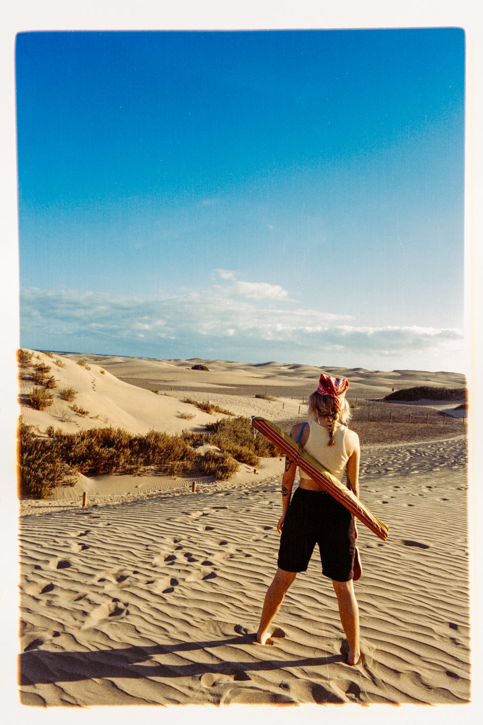 Henrike mitten im Sand, mit dem Rücken zur Kamera und in die Ferne guckend, auf Gran Canaria