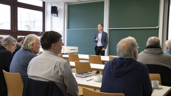 Personen in einem Hörsaal, die Professor Dr.-Ing. Oliver Büchel zuhören.