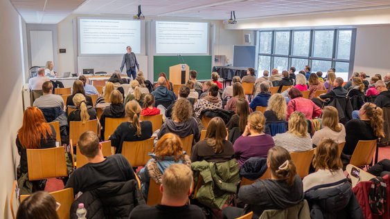Karl-Heinz Gröpler steht vor über 70 Anleiter*innen und tritt mit ihnen in einen intensiven Dialog, um die Zusammenarbeit zu verbessern.