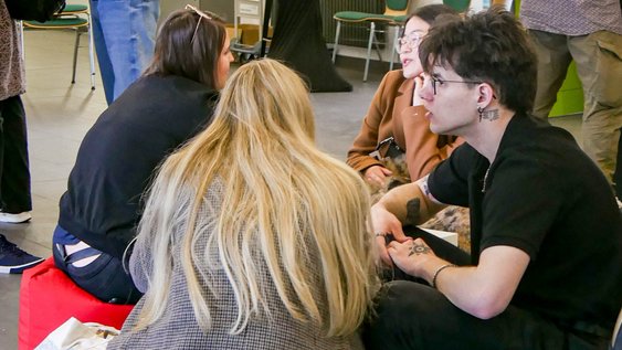 Eine Gruppe von Studierenden sitzt zusammen und unterhält sich.