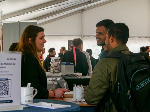 Info-Stand eines Unternehmens mit vielen Personen. 