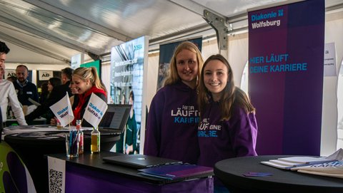 Zwei Personen von der Diakonie am Info-Stand.