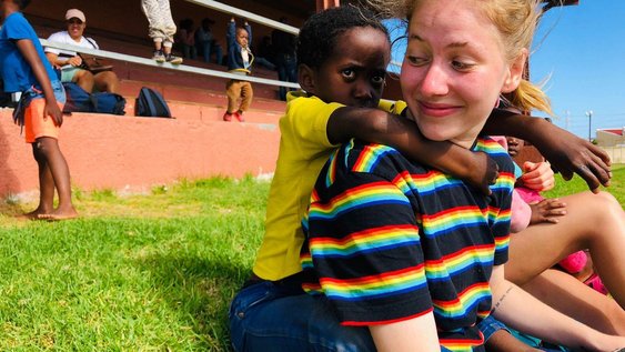 Studierende mit einem kleinen Kind in einem sozialen Projekt in Südafrika. Sie hat dort ihr Auslandspraktikum gemacht.