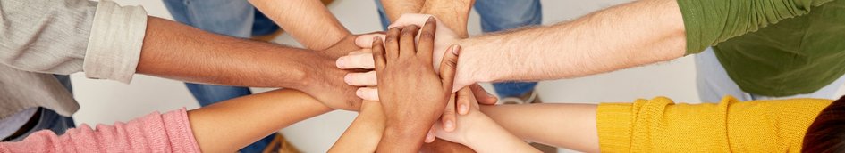 Menschen legen ihre Hände aufeinander. Im Bildausschnitt sind nur Arme und Hände zu sehen