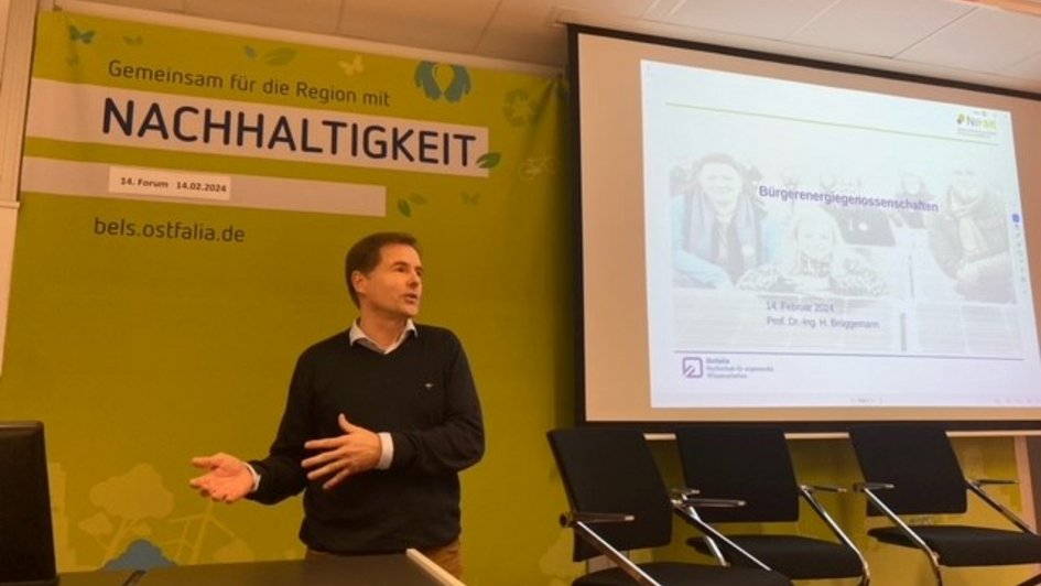 Prof. Dr.-Ing. Holger Brüggemann bei seinem Vortag über die Niedersächsische Lernfabrik für Ressourceneffizienz (NiFaR). Er steht am Rednerpult und gestikuliert mit seinen Händen. 