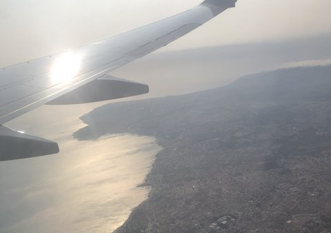 Bird's eye view from an airplane of a land mass at sunset