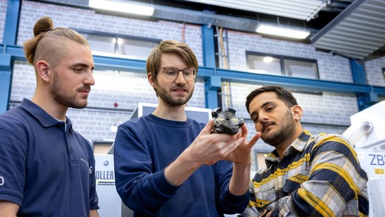 Studierende der Ostfalia Hochschule sehen sich ein Werkstück an, das sie in einem Labor selbst entwickelt haben.