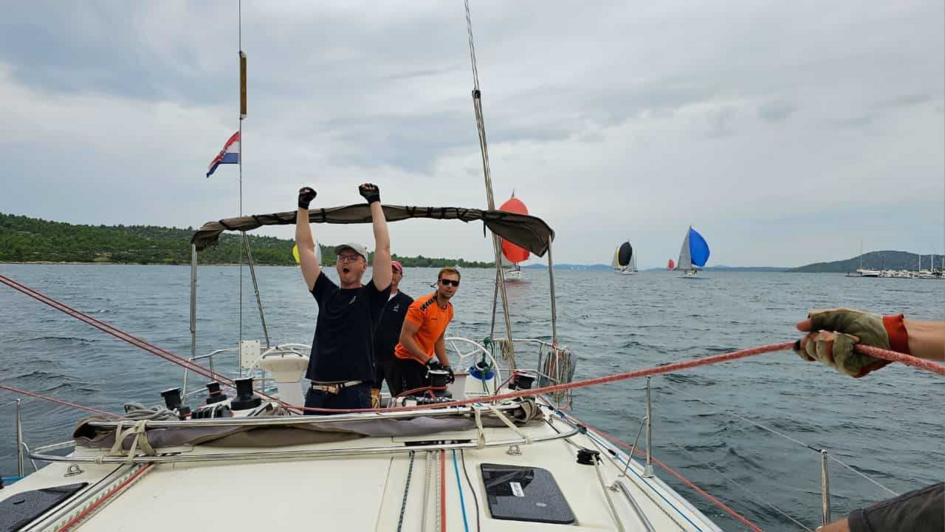 Jubelnde Teilnehmer*innen der Crew auf dem Segelboot beim Sieg des Lessing-Cups