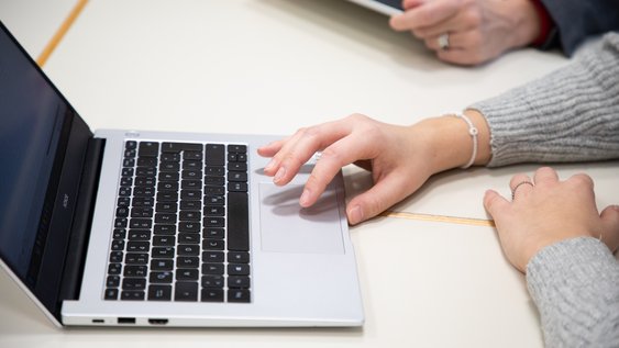 Person tippt auf dem Laptop