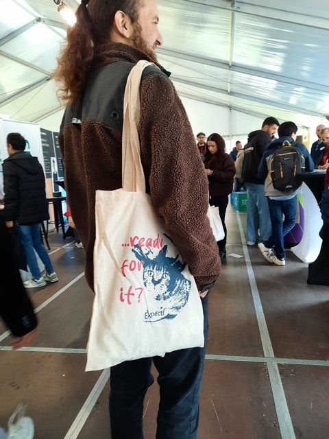 Messebesucher mit der Messetasche, auf welcher die berühmte Messe-Katze abgebildet ist.