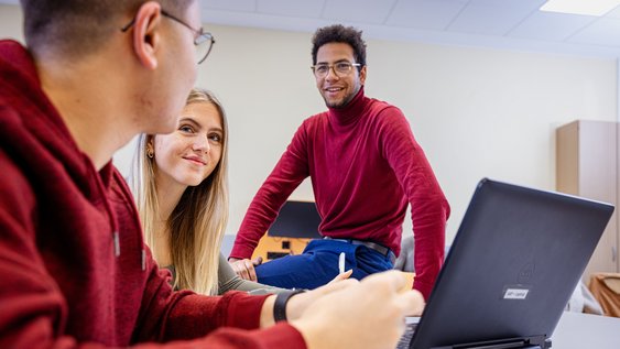 Drei Studierende der Ostfalia recherchieren mit einem Laptop.