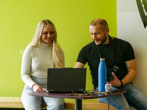 Roman Brodel bespricht mit einer Messebesucherin die Ergebnisse des Fotoshooting und sie wählen ein passendes Bewerbungsfoto aus. 