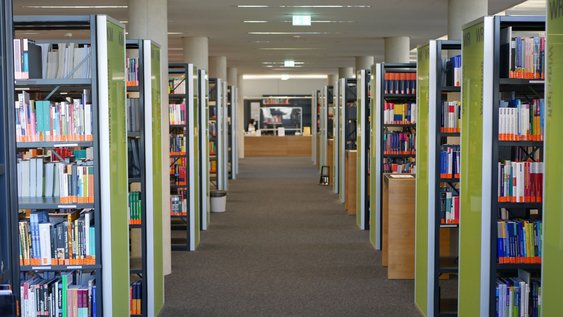 Blick in den Mittelgang des Lesesaals der Bibliothek Salzgitter mit Buchaufstellung und Onlinekataloge
