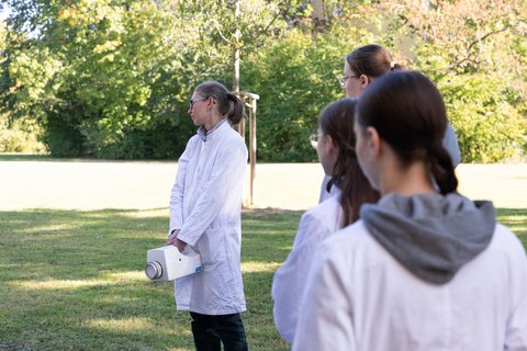 Schüler und Schülerinnen draußen am Exer, um eine Luftprobe zu sammeln (öffnet Vergrößerung des Bildes)