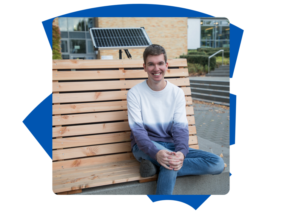 Student BAstian der Fakultät Versorgungstechnik sitzt draußen auf der Bank am Campus Wolfenbüttel und schaut in die Kamera.