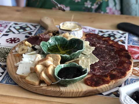 Ein voller Holzteller mit verschiedenen Aufstrichen und Belägen für beigelegte Brotscheiben (öffnet Vergrößerung des Bildes)