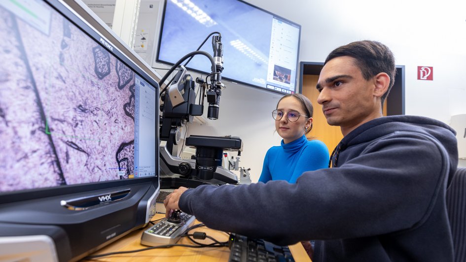 Zwei Studierende arbeiten an einem Mikroskop