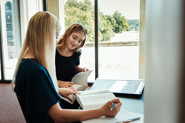 Studierende im Gespräch zur Literatur in der Bibliothek