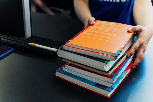 Eine Person mit einem Bücherstapel
