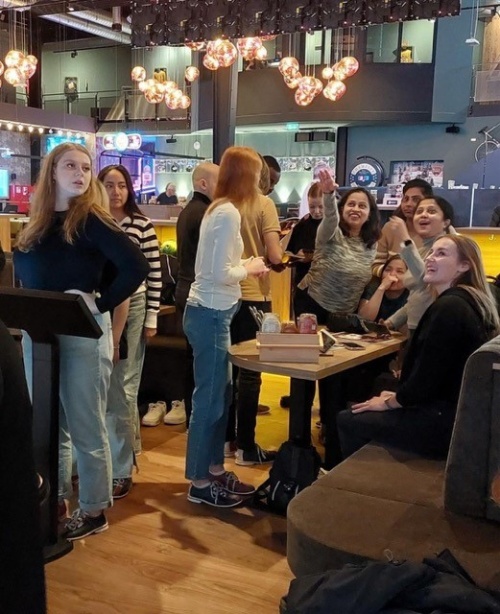 Personen sitzen zusammen in einer gut beleuchteten, modernen Bar