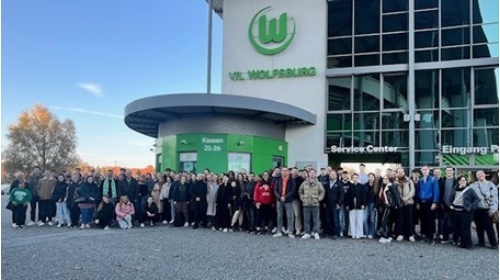 Studierende der Fakultät Wirtschaft stehen vor dem Stadion des VFL Wolfsburg