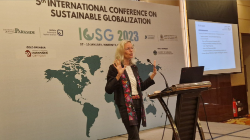 Dr. Sander spricht vor vor einem Plakat der "International Conference of Sustainable Globalization"