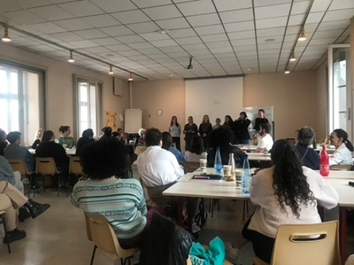 Ein gut gefüllter Konferenzraum. Vorne stehen Redner:innen, die übrigen Teilnehmenden sitzen und hören zu