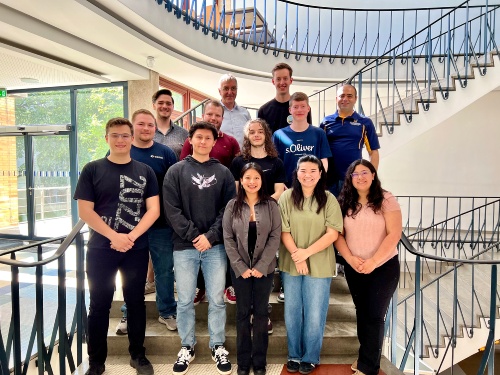 Personengruppe posiert auf einer Wendeltreppe 