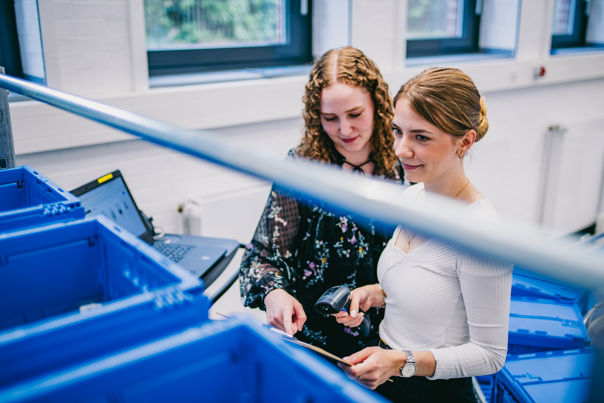 Zwei Studierende bei der Anwendung eines Barcodescanners zur Erfassung von Lagerbeständen.