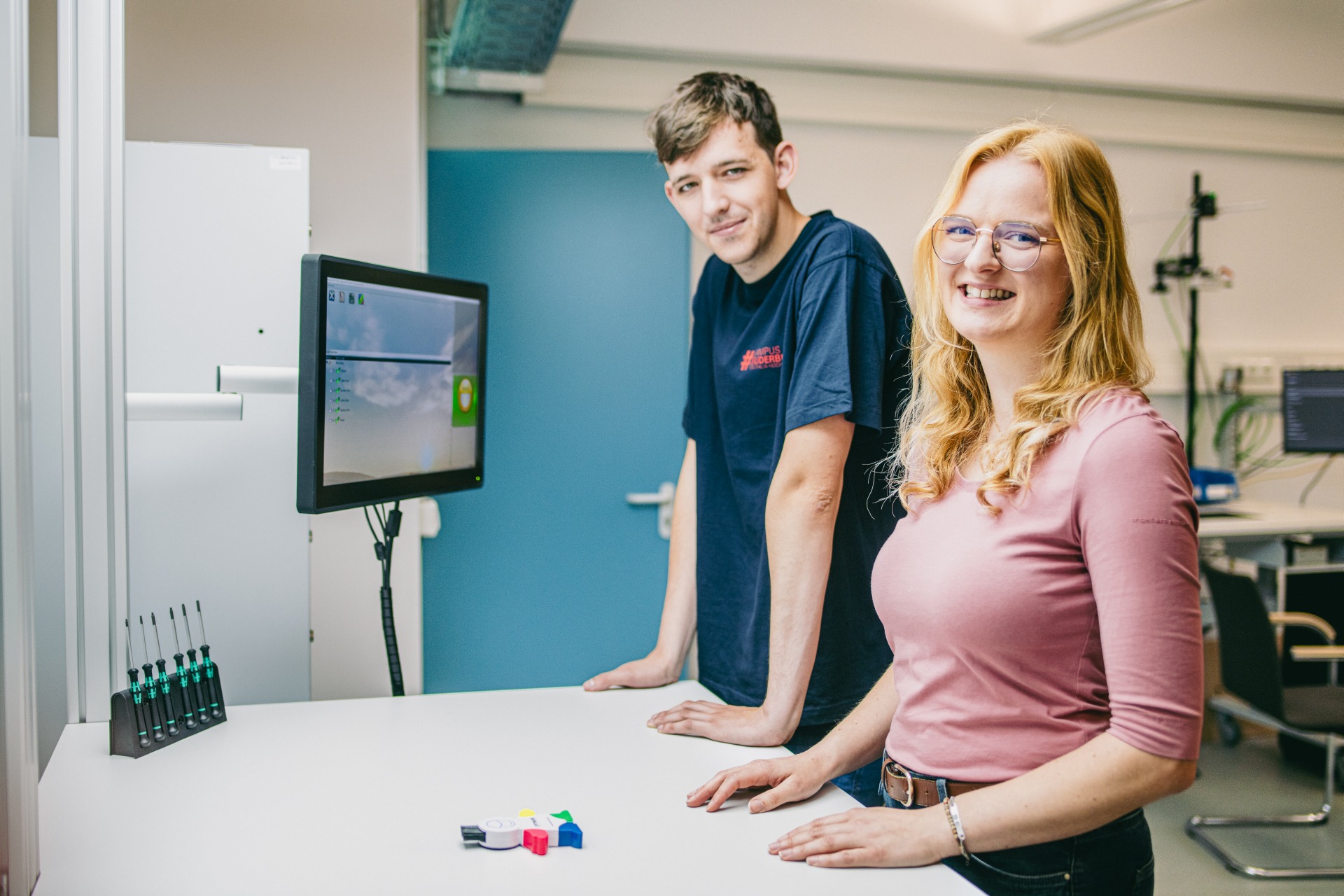 Zwei Studierende, die mit Hilfe des Digitalen Assistenzsystems "Schlauer Klaus" ein Produkt korrekt zusammengefügt haben.